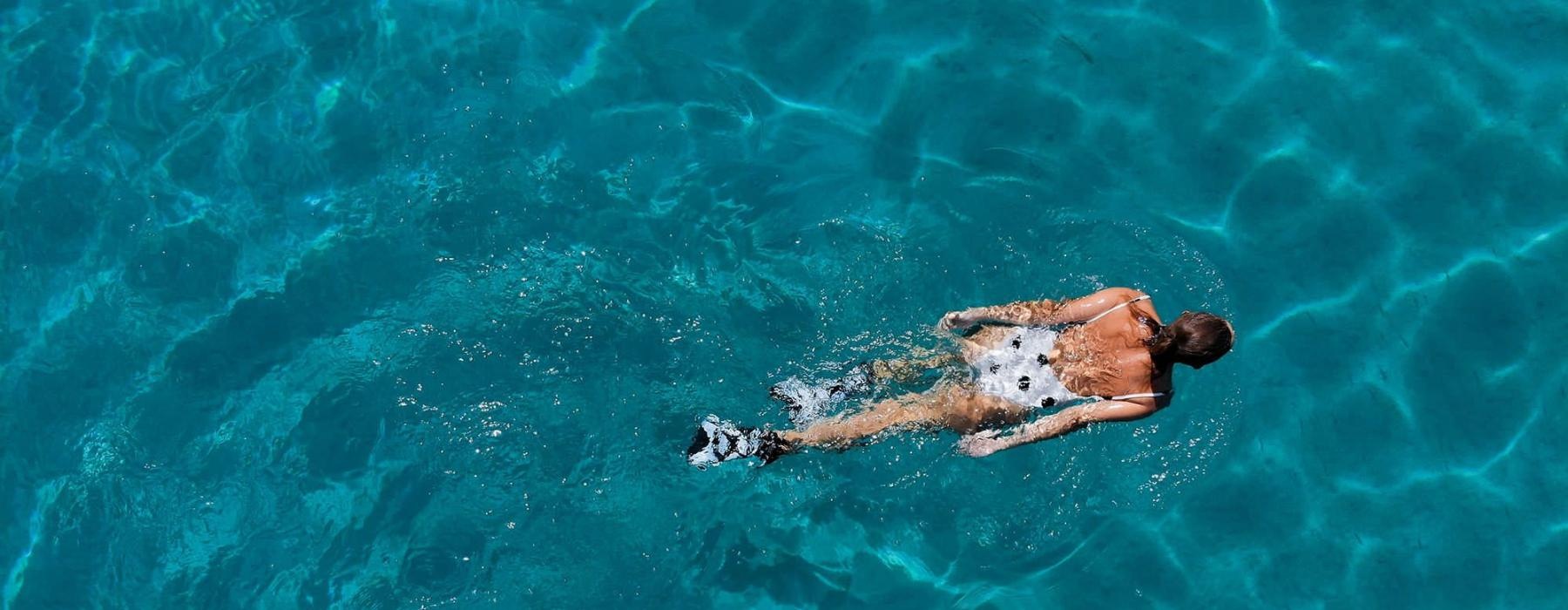 overhead shot of a woman swimming in a pool